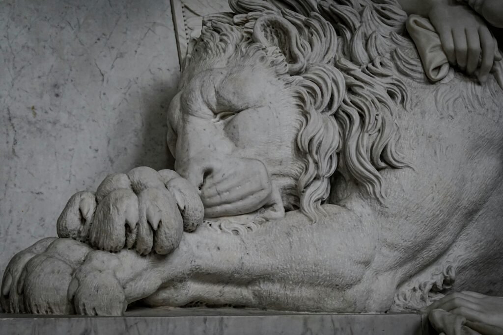 Intricately carved marble lion sculpture captures elegance and regality indoors.