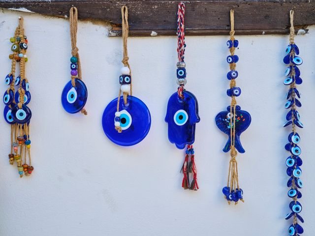 Colorful handmade evil eye wall decorations hanging on a white wall.